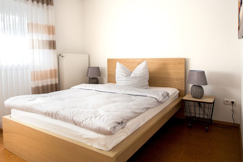 Helles Gästezimmer mit Doppelbett am Fenster